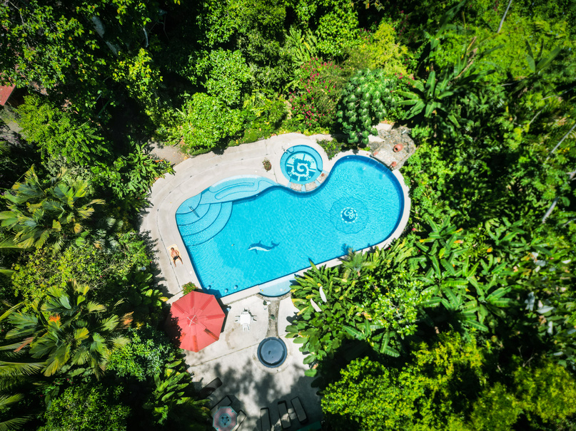 An aerial photo of our large crystal blue swimming pool located in the middle of the lush Costa Rican rainforest 