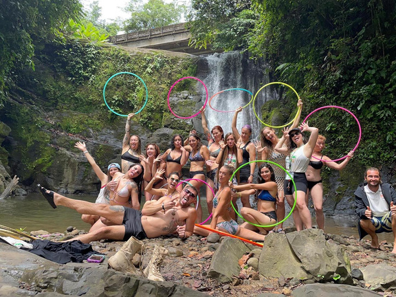 The Oasis Hoop Retreat poses as a group in front of a waterfall in Costa Rica